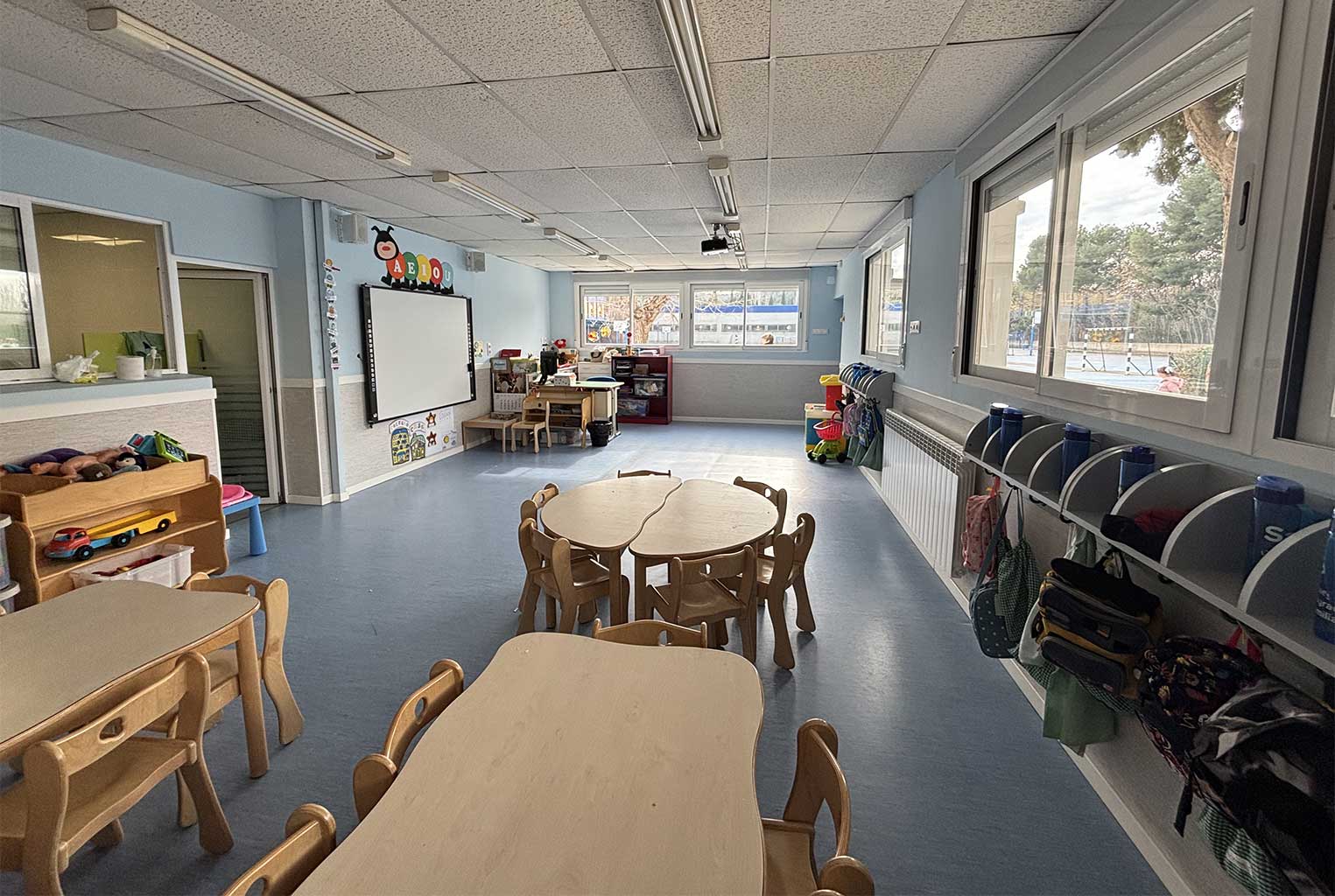 aula de infantil con mesas de madera